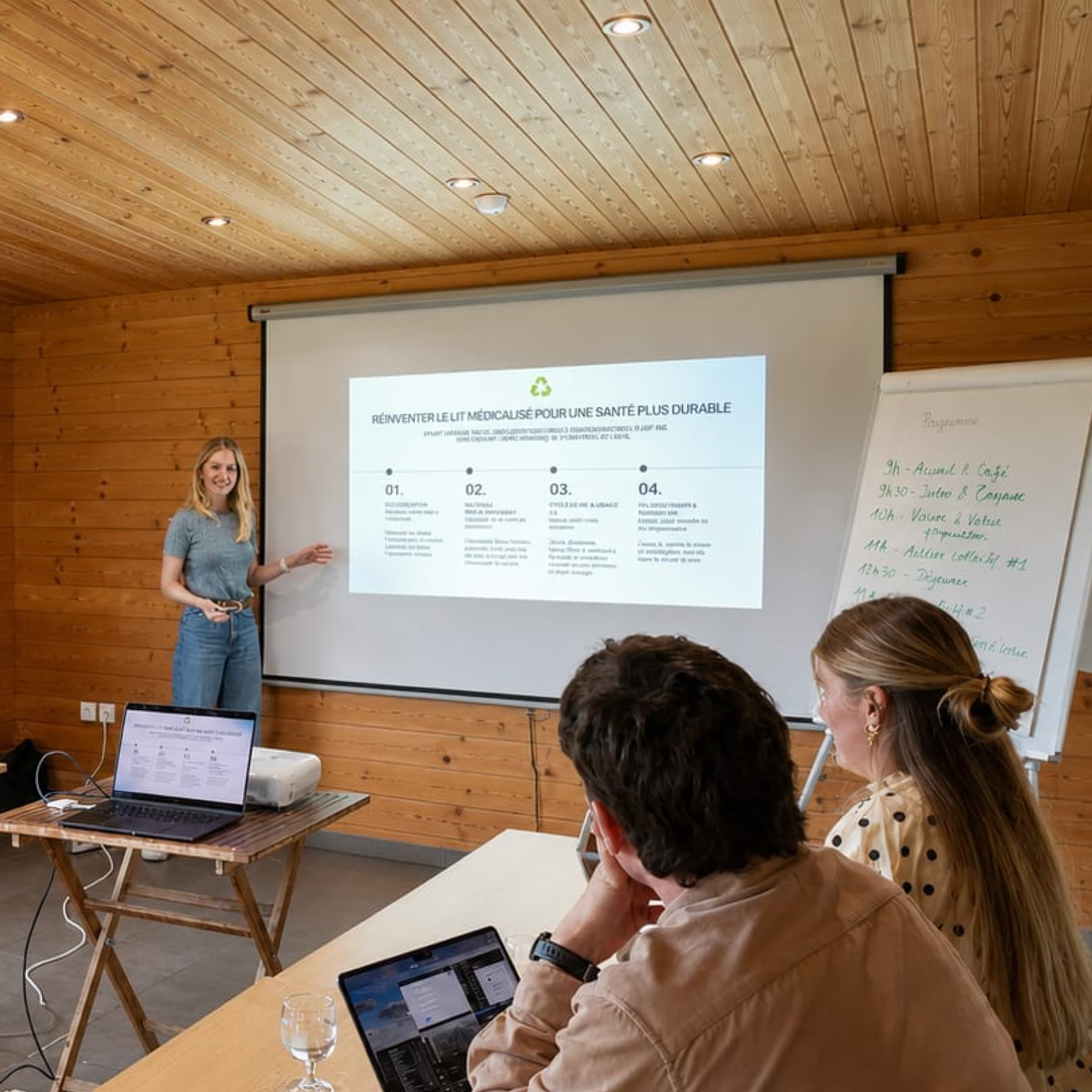 Salle de réunion équipée d'un vidéoprojecteur, d'un écran et d'un paperboard